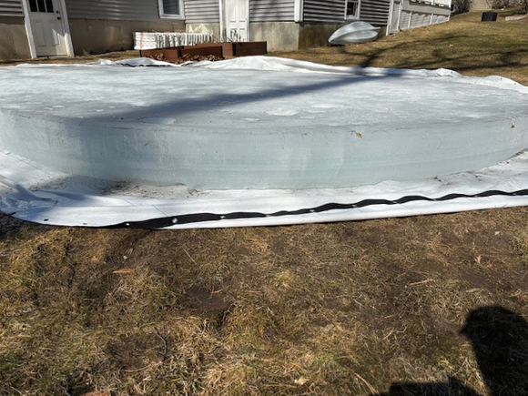 A backyard rink frozen on grass