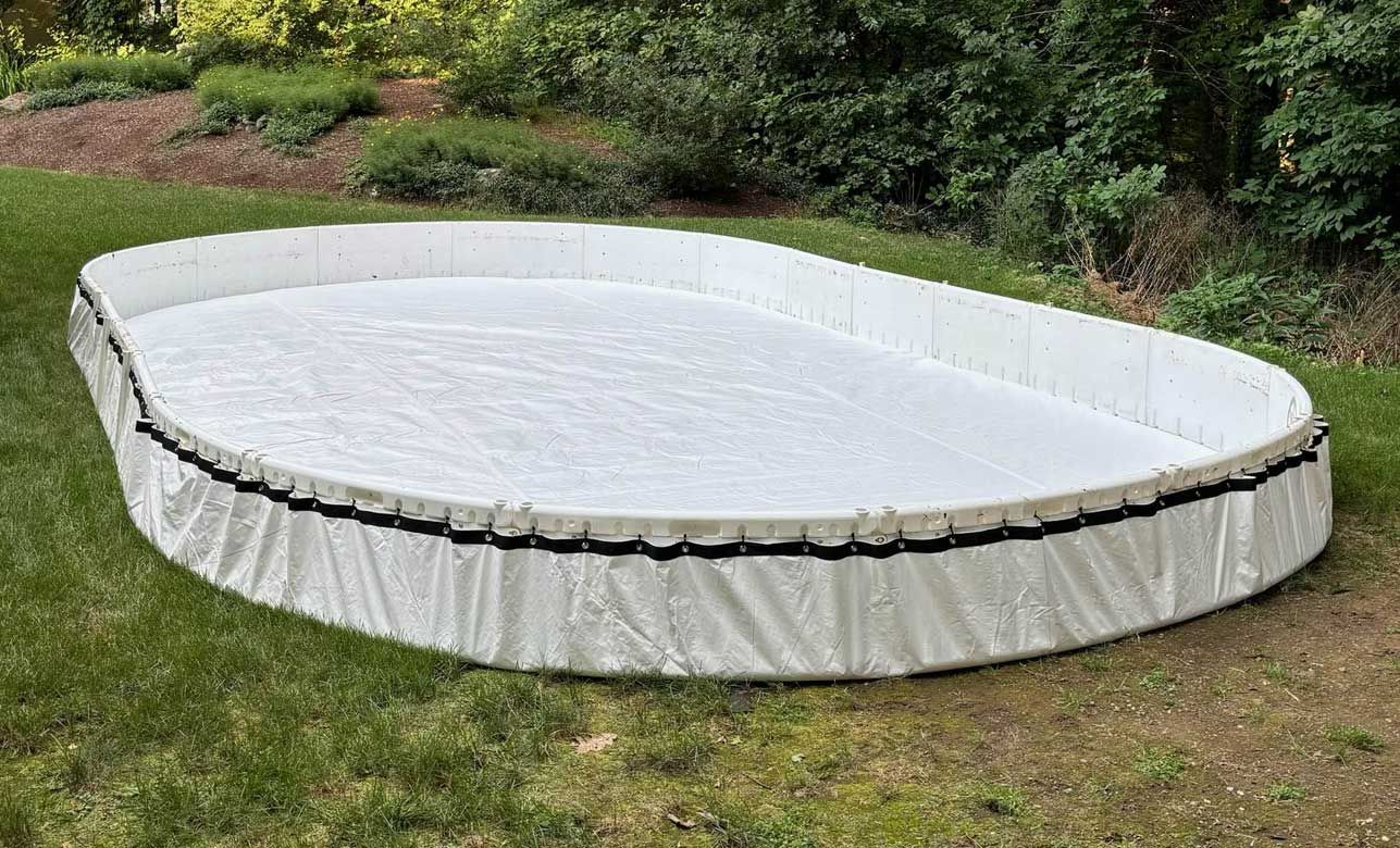 A junior-sized backyard ice hockey rink on grass