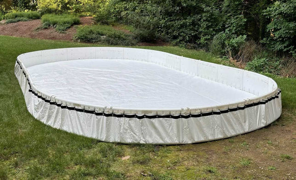 A junior-sized backyard ice hockey rink on grass